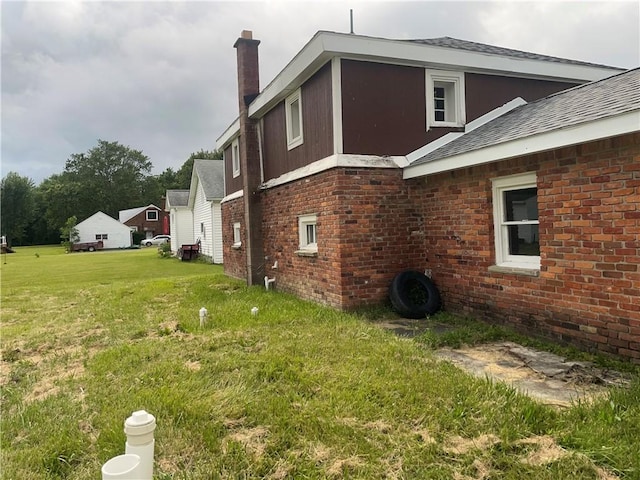 view of side of home with a yard