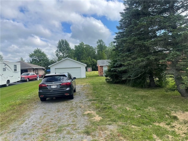 view of yard with a garage and an outbuilding