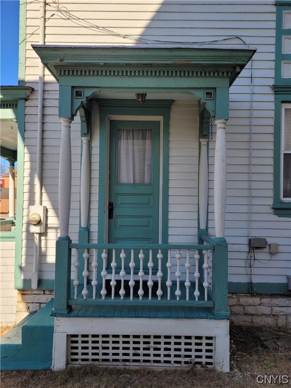 view of exterior entry featuring covered porch