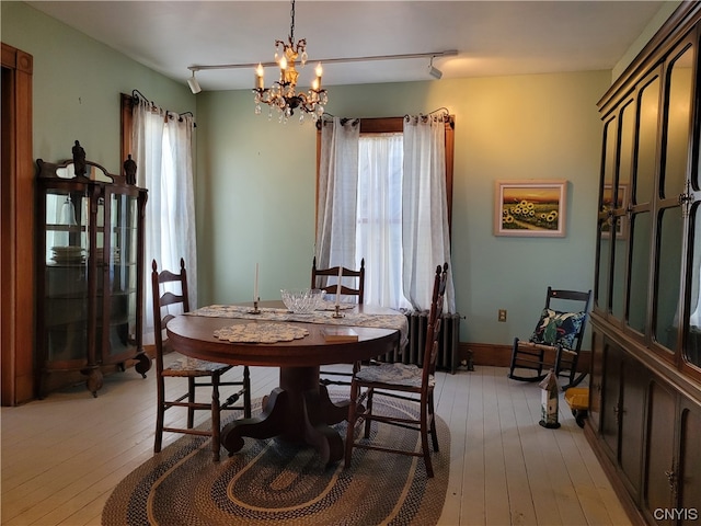 dining space with a notable chandelier, light hardwood / wood-style floors, and a healthy amount of sunlight