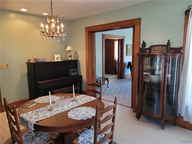 dining space featuring a notable chandelier and light colored carpet