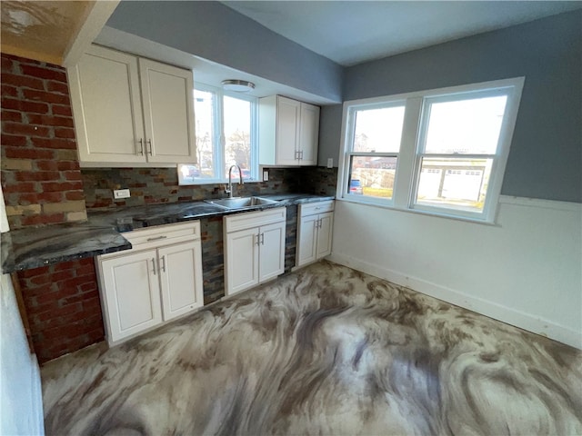 kitchen featuring sink, white cabinetry, and decorative backsplash