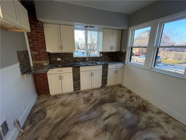 kitchen with a wealth of natural light, sink, decorative backsplash, and white cabinets