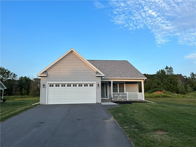 view of front of house featuring covered porch, a front lawn, and a garage