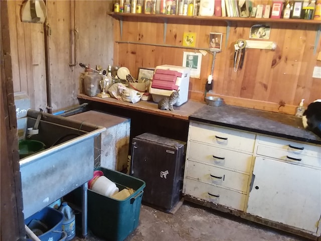 misc room with wooden walls and concrete floors