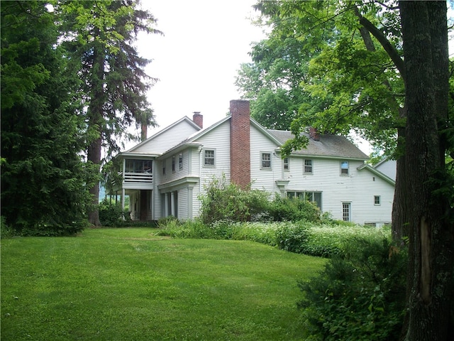 exterior space featuring a balcony and a lawn