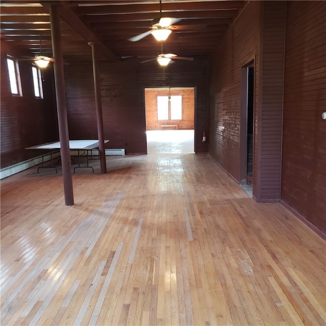 interior space featuring light hardwood / wood-style flooring, ceiling fan, and a baseboard heating unit