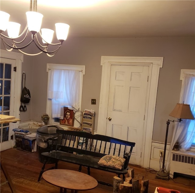 dining space featuring radiator heating unit, a notable chandelier, and dark hardwood / wood-style floors