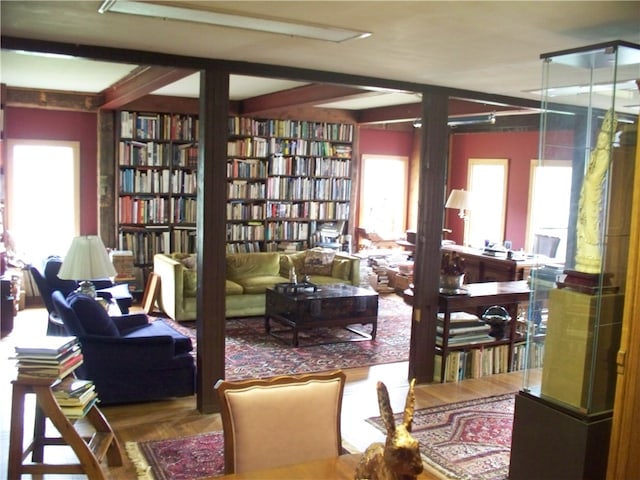 living room with beam ceiling and wood-type flooring