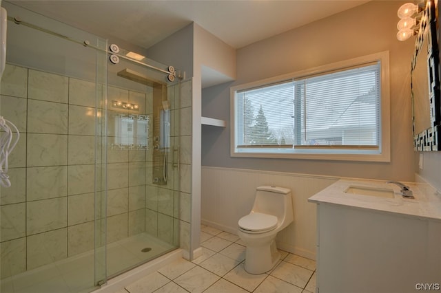 bathroom with a shower with shower door, vanity, toilet, and tile floors