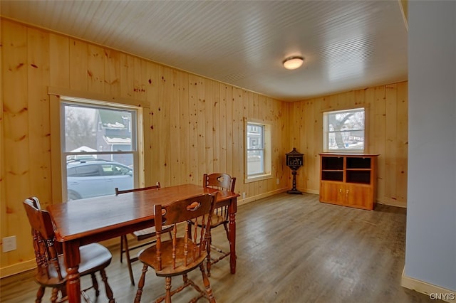 dining area featuring wood walls and hardwood / wood-style flooring