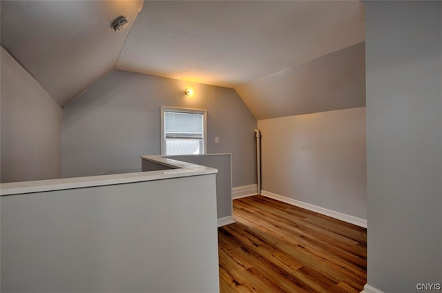 bonus room featuring lofted ceiling and light hardwood / wood-style flooring