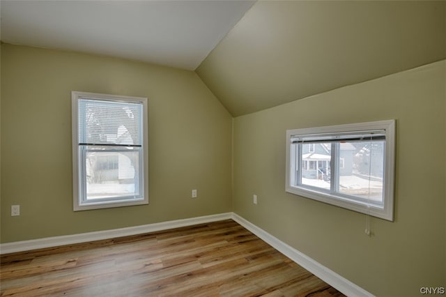 bonus room featuring a wealth of natural light, hardwood / wood-style floors, and lofted ceiling