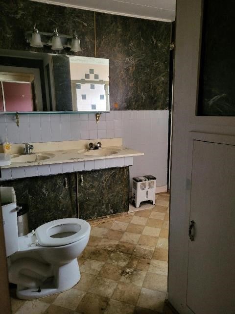 bathroom featuring toilet, tasteful backsplash, and vanity