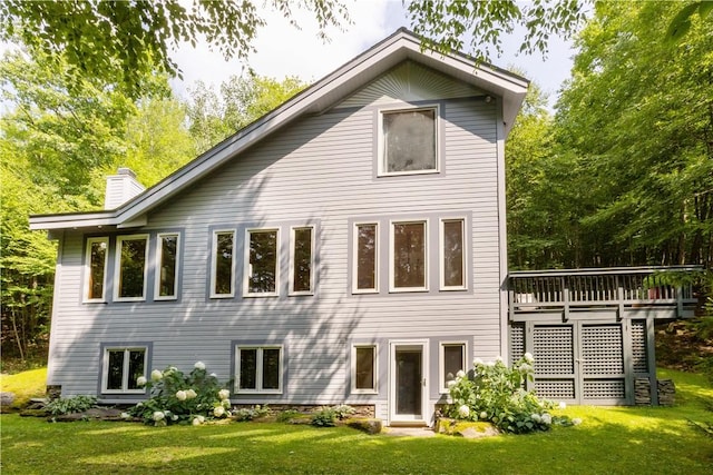 back of house with a wooden deck and a lawn