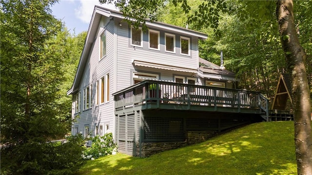 rear view of house featuring a lawn and a deck