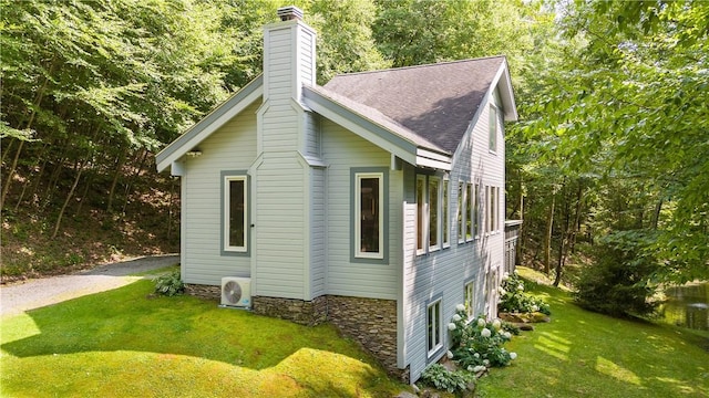 view of side of home featuring ac unit and a lawn