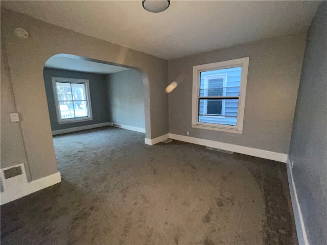 unfurnished room with dark carpet