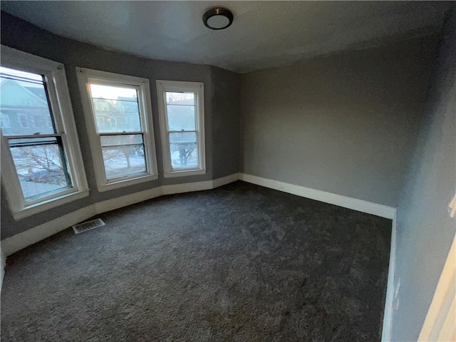 empty room featuring dark colored carpet