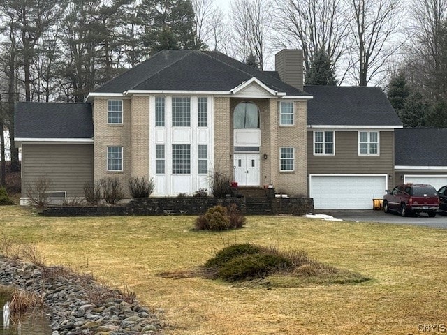 view of front of house featuring a front lawn and a garage