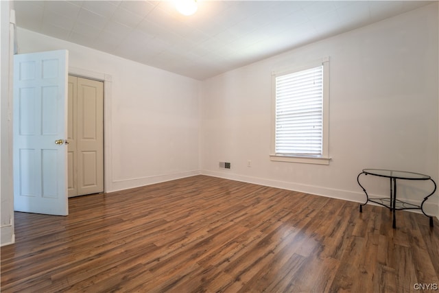 spare room with dark hardwood / wood-style floors