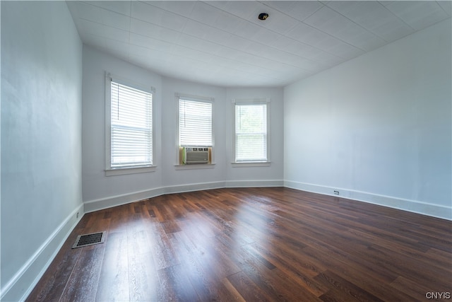 spare room with dark wood-type flooring and a healthy amount of sunlight