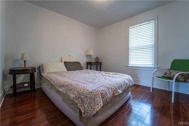 bedroom with multiple windows and dark hardwood / wood-style flooring