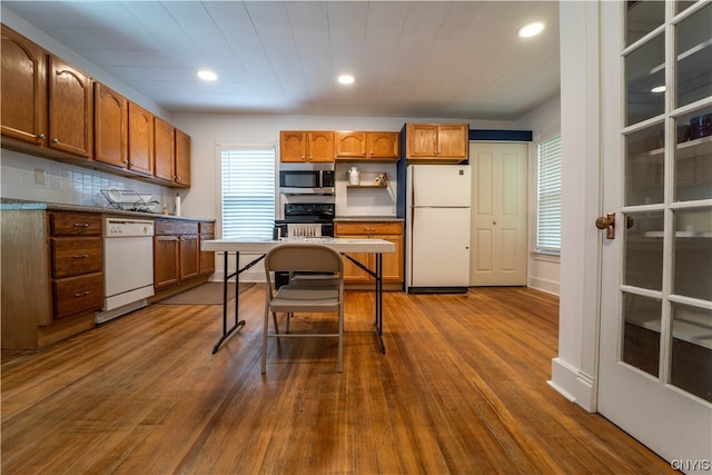 kitchen featuring white appliances, tasteful backsplash, and hardwood / wood-style floors