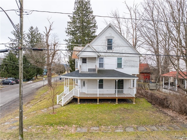 rear view of house featuring covered porch and a yard