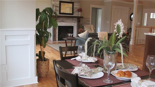 dining space featuring light wood-type flooring and a fireplace