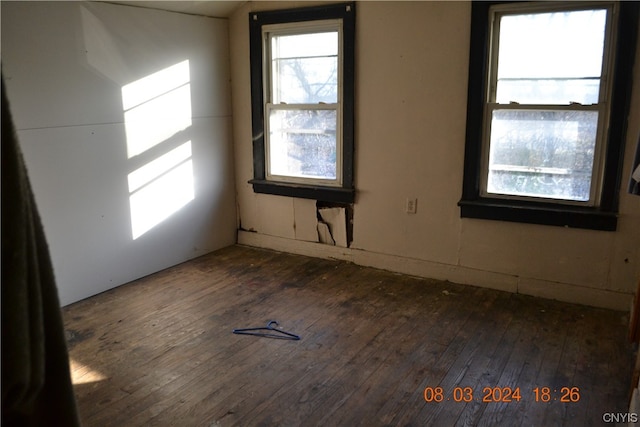 unfurnished room featuring plenty of natural light and dark hardwood / wood-style flooring