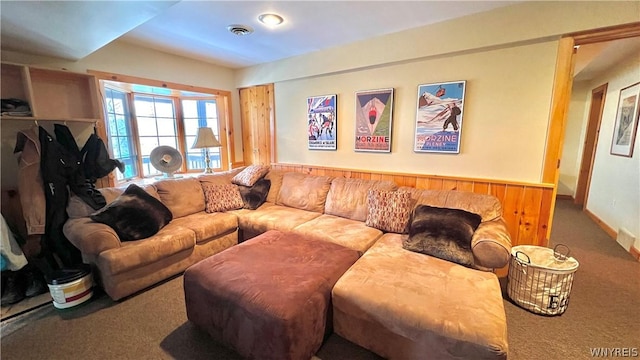 living room featuring carpet floors and wood walls