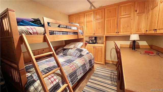 bedroom featuring built in desk and track lighting