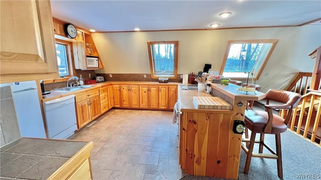 kitchen with sink, white appliances, tile counters, and ornamental molding