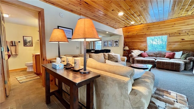 carpeted living room with wood ceiling, plenty of natural light, and wooden walls