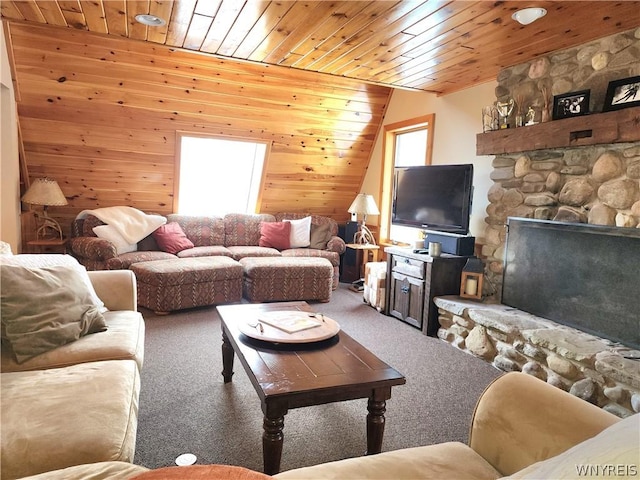 carpeted living room with lofted ceiling, a stone fireplace, wooden ceiling, and wooden walls