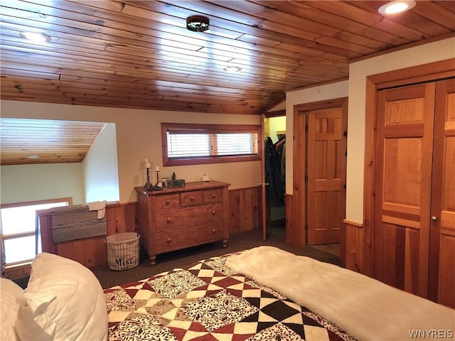 bedroom with vaulted ceiling, wooden ceiling, a closet, and wood walls