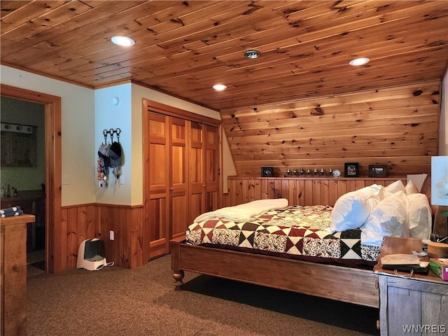 bedroom with crown molding, wood ceiling, wooden walls, carpet flooring, and a closet