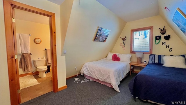 bedroom with lofted ceiling, ensuite bath, and carpet floors