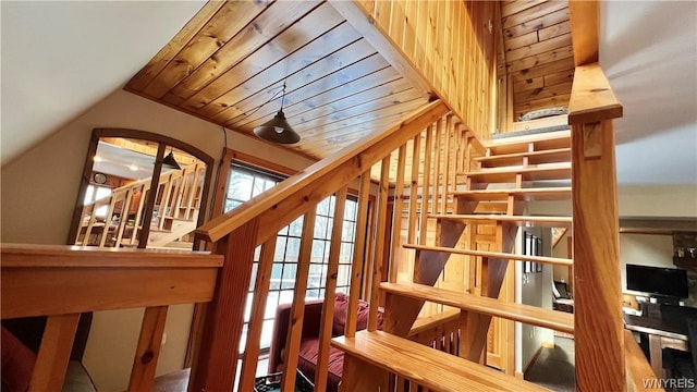 staircase featuring lofted ceiling and wooden ceiling