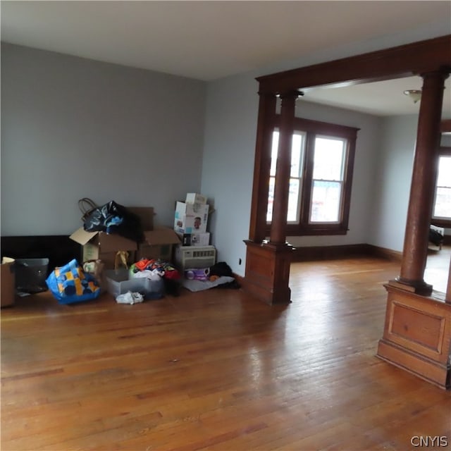 misc room with decorative columns and hardwood / wood-style flooring