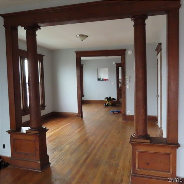 interior space with decorative columns and hardwood / wood-style flooring