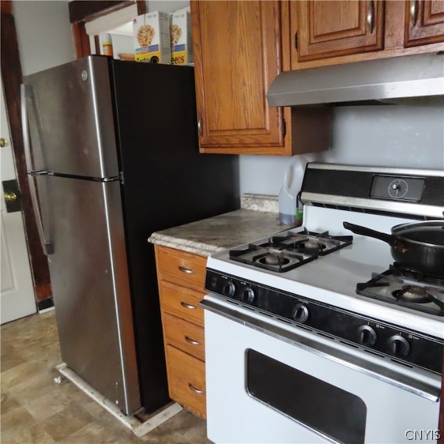 kitchen with tile flooring, white range with gas cooktop, and stainless steel fridge