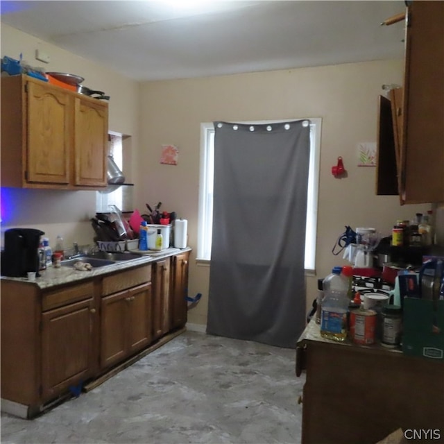 kitchen featuring sink, light tile floors, and a wealth of natural light