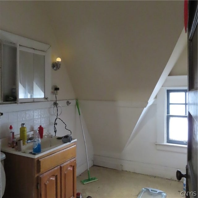 bathroom with lofted ceiling and vanity