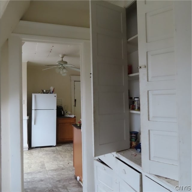 interior space featuring light tile floors, ceiling fan, and white fridge