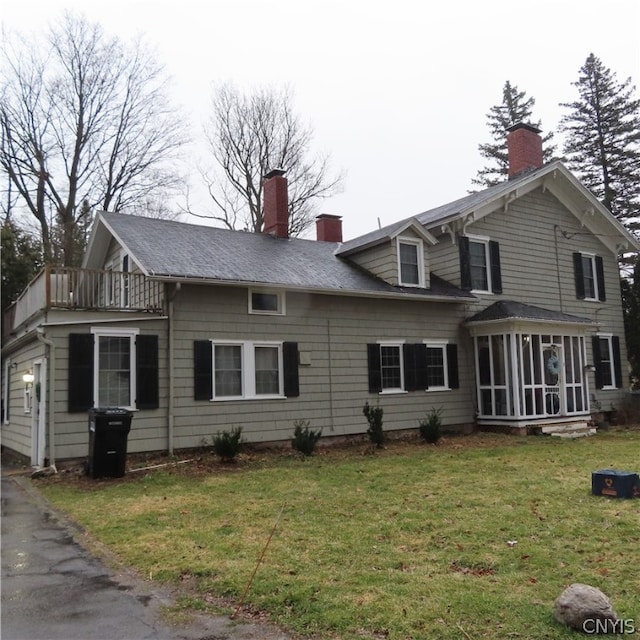 view of front of property with a front lawn and a balcony