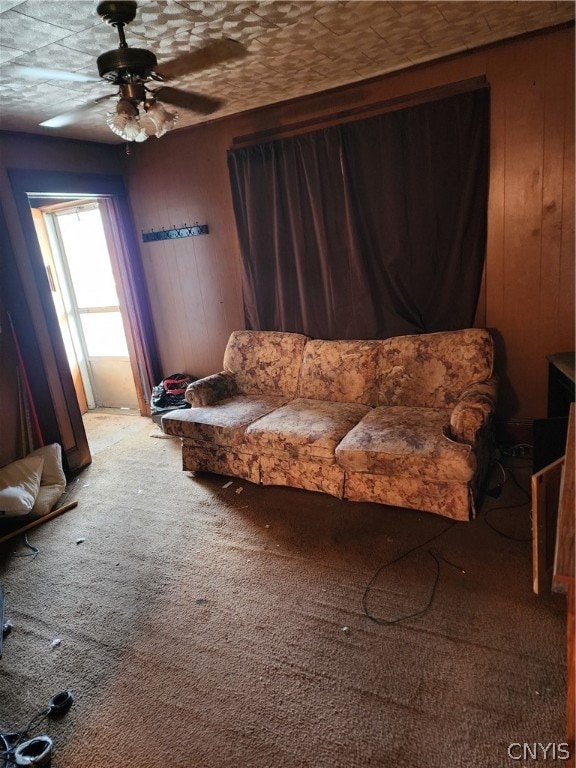 living area with carpet and ceiling fan