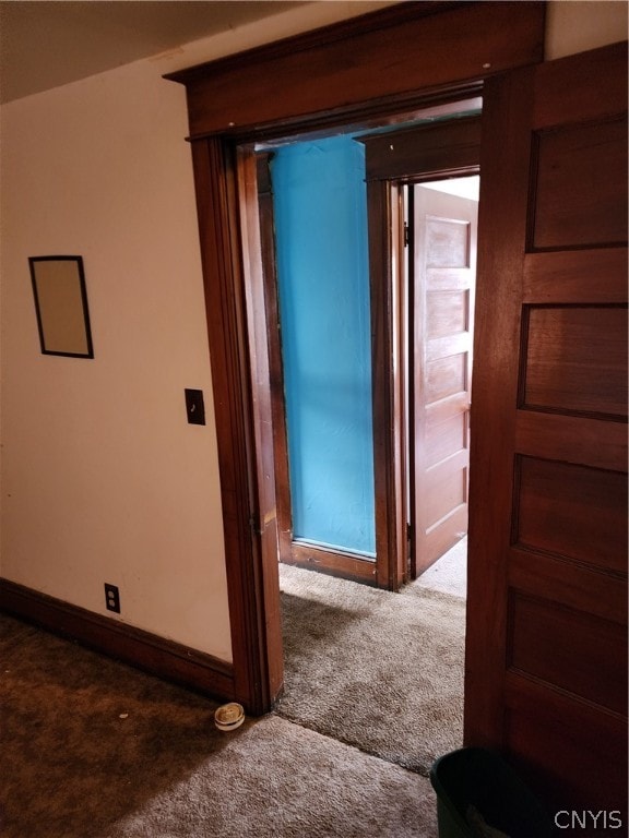 hall featuring dark colored carpet