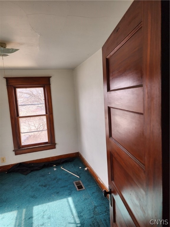 unfurnished room with dark carpet